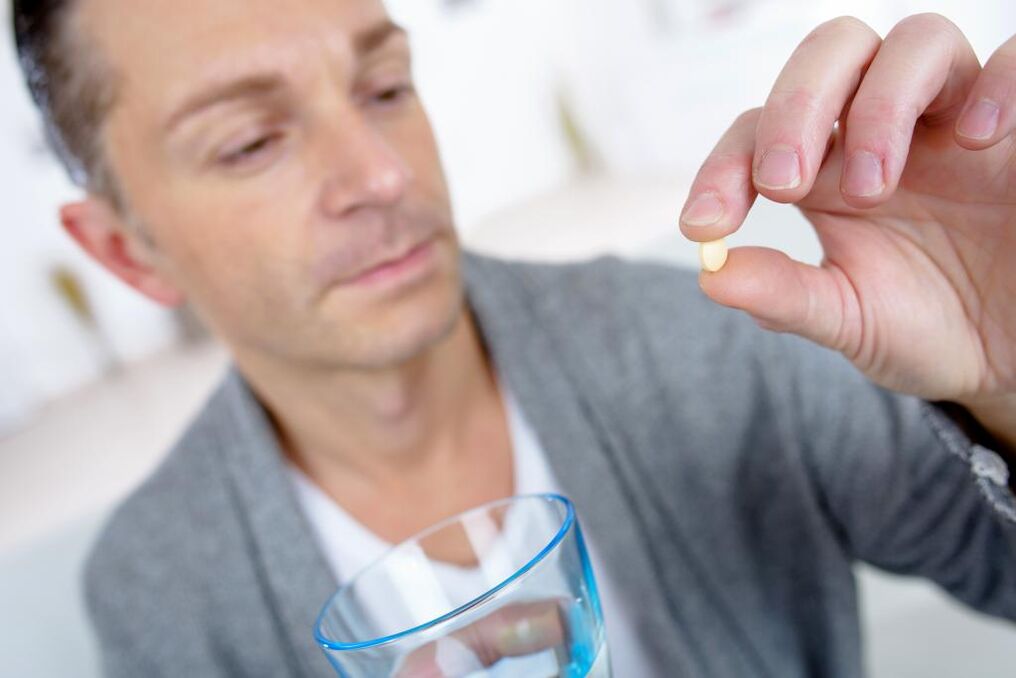 een man neemt een pil om de potentie te vergroten